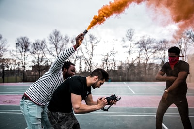 男人与橙色烟雾可以站在男人拿着相机

